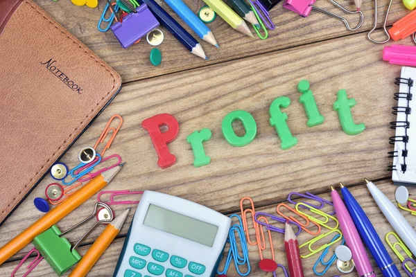 Profit word and office tools on wooden table — Stock Photo, Image