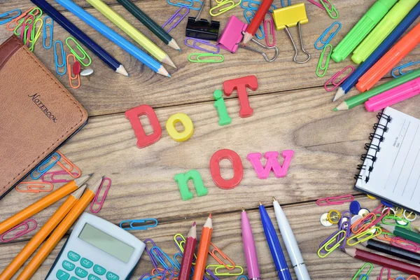 Do it now word and office tools on wooden table — Stock Photo, Image