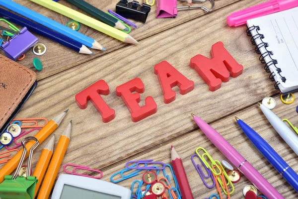 Team word and office tools on wooden table — Stock Photo, Image