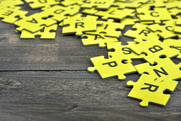 Puzzle on wooden table — Stock Photo, Image