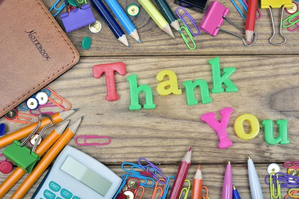 Слово "спасибо" и офисные инструменты на деревянном столе — стоковое фото