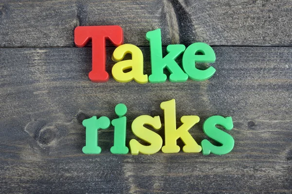 Take risks on wooden table — Stock Photo, Image