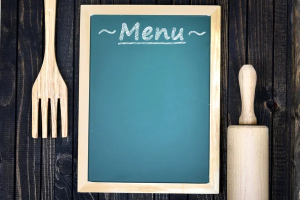 Kuchyňské náčiní a menu na stole — Stock fotografie