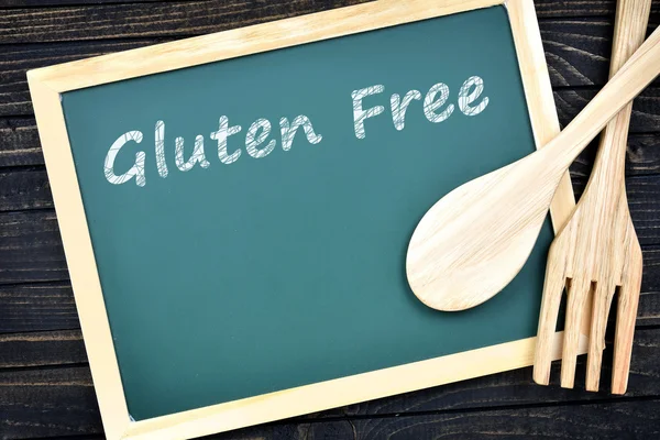 Gluten vrije tekst op een groen bord met vork en lepel — Stockfoto