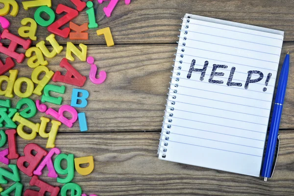 Help text on notepad and magnetic letters — Stock Photo, Image