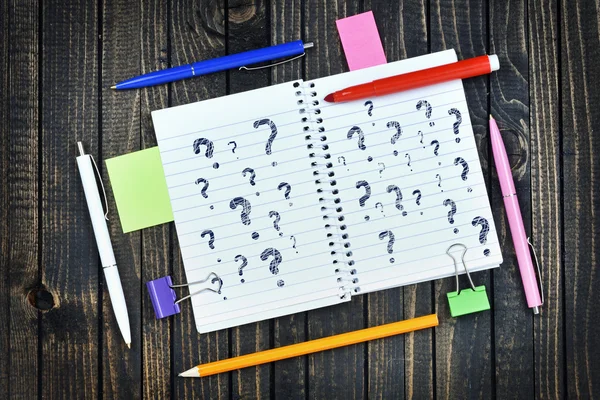 Perguntas texto no bloco de notas e ferramentas de escritório — Fotografia de Stock