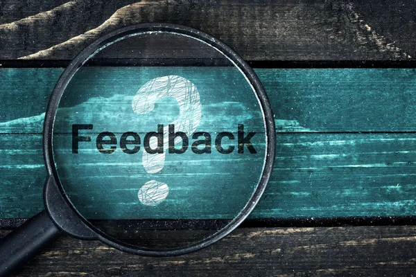 Feedback text painted and magnifying glass on table — Stock Photo, Image