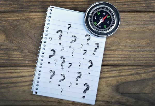 Questions text and compass on wooden table — Stock Photo, Image