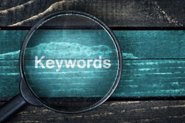 Keywords text painted and magnifying glass on table clipart