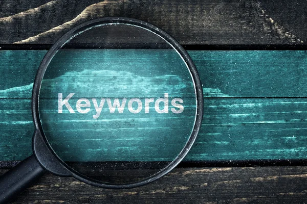 Keywords text painted and magnifying glass on table — Stock Photo, Image