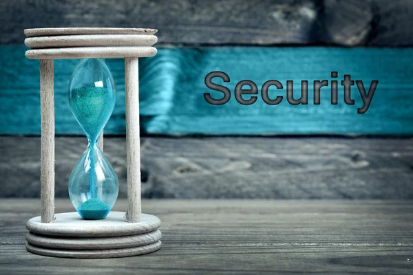 Säkerhet text och timglas på bord — Stockfoto