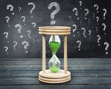 Soru işaretleri ve masada kum saati