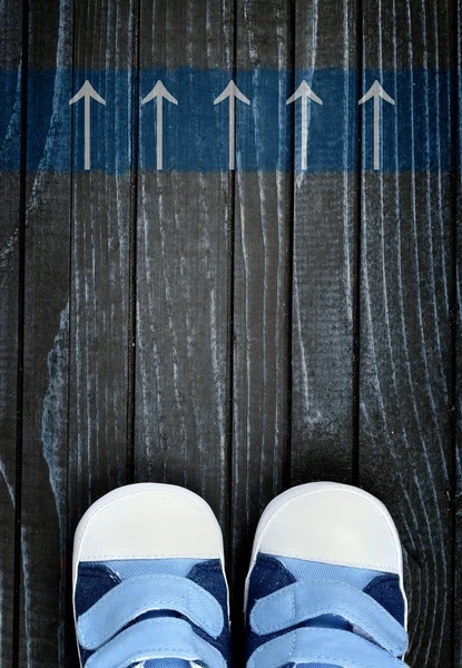 Pijlen bericht en kid schoenen op verdieping — Stockfoto