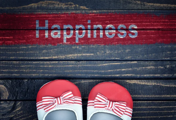 Повідомлення про щастя та дитяче взуття на підлозі — стокове фото