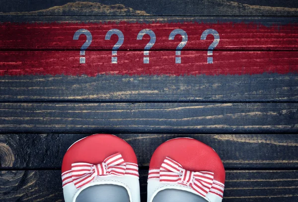 Question marks message and kid shoes on floor — Stock Photo, Image