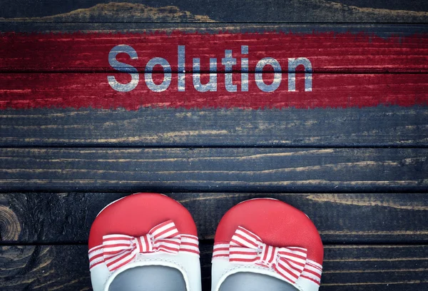 Mensagem de solução e sapatos de criança no chão — Fotografia de Stock