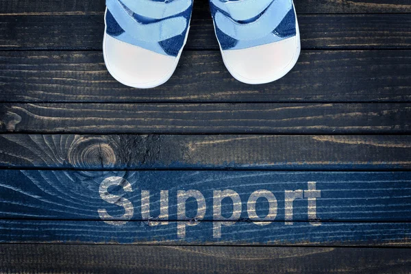 Послание поддержки и детская обувь на полу — стоковое фото