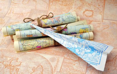 old rolled maps and paper airplane