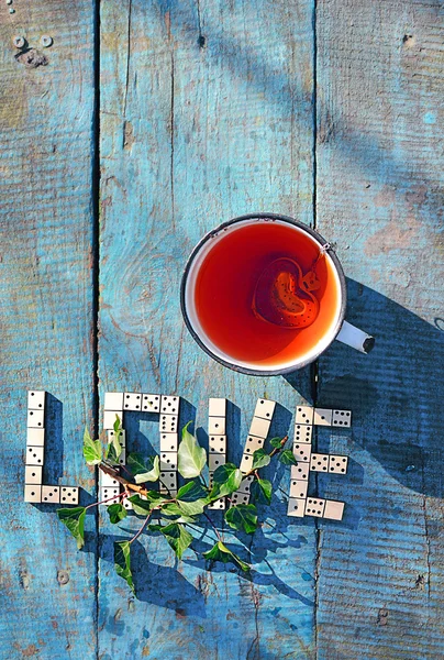 Palavra de amor? ? de dominó de madeira com chá de xícara — Fotografia de Stock