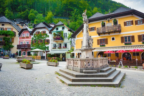 Monumento religioso com casas coloridas típicas em Hallstatt — Fotografia de Stock