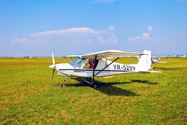 Weißes Flugzeug auf einer grünen Wiese — Stockfoto