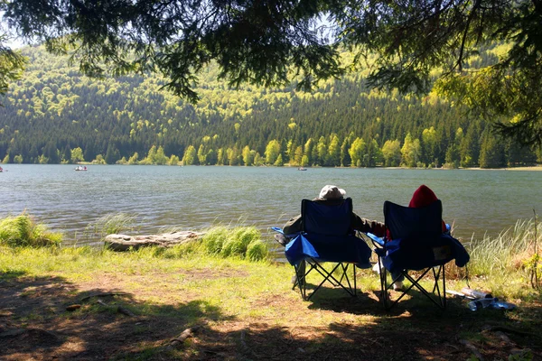 Tourists Couple contemplating on shore lake — Stock Photo, Image