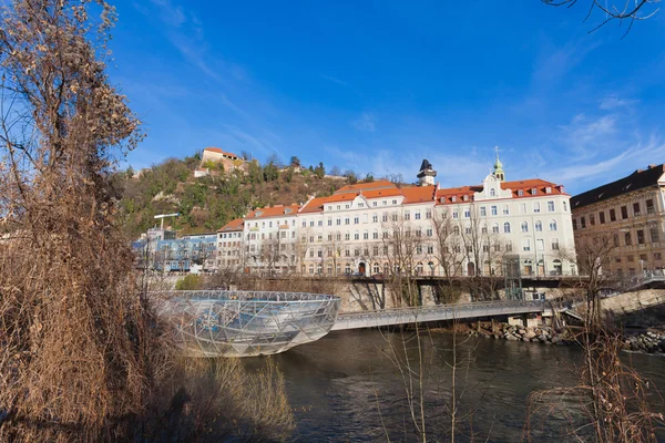 Island on Mur river connected by a modern steel and glass bridge — Stock Photo, Image