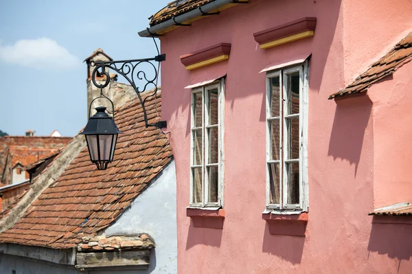 Façade rose avec fenêtres blanches et lampadaire — Photo