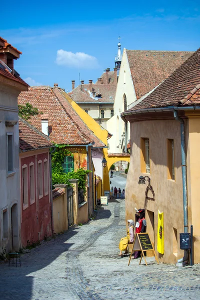 Old stone paved street with tourists from Sighisoara fortress — Stock Photo, Image