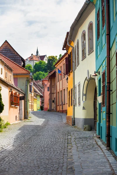 Piedra pavimentada antigua calle con casas de colores de Sighisoara fortr — Foto de Stock