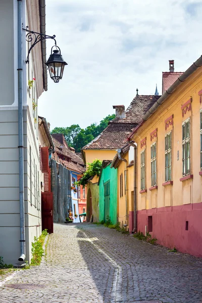 Si renkli evden ile eski taş döşeli sokakta sokak lambası — Stok fotoğraf
