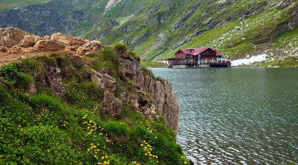 Idílica vista con cottege en la orilla del lago Balea en la montaña Fagaras — Foto de Stock