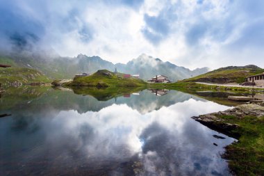 Balea göl kıyısında Fagaras tipik lodges ile pastoral görünümü 