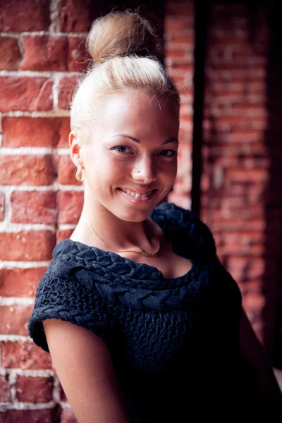 Tuğla duvar arka plan üzerinde genç kadın