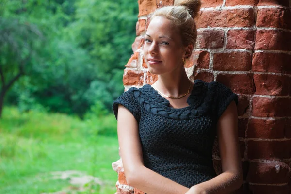 Tuğla duvar arka plan üzerinde genç kadın