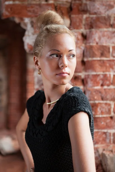Tuğla duvar arka plan üzerinde genç kadın