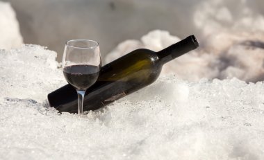 Bir bardak kırmızı şarap ve şişe.