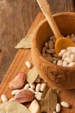 Doğal dokulu ahşap arka plan üzerinde ahşap bir tencerede fasulye