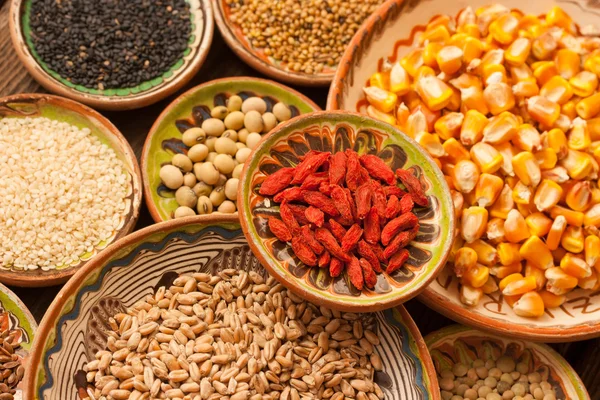 Various grain beans in small clay plates on natural textured woo — Stock Photo, Image