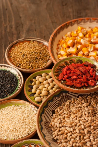 Various grain beans in small clay plates on natural textured woo — Stock Photo, Image