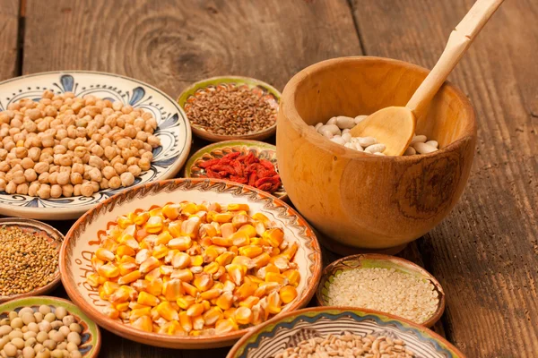 Various grain beans in small clay plates on natural textured woo — Stock Photo, Image