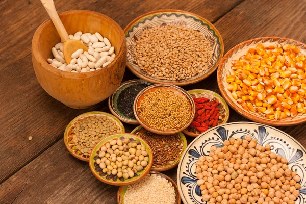 Various grain beans in small clay plates on natural textured woo — Stock Photo, Image