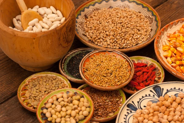 Various grain beans in small clay plates on natural textured woo — Stock Photo, Image
