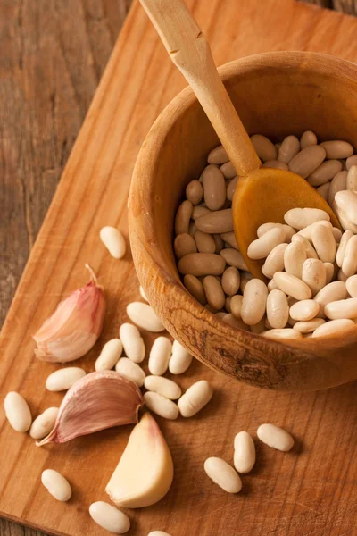 Beans in a wood pot on natural textured wood background — Stock Photo, Image