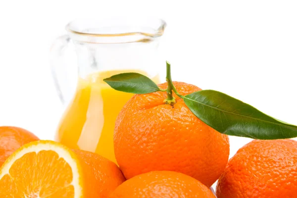 Close view of orange fruits and jug of fresh juice — Stock Photo, Image