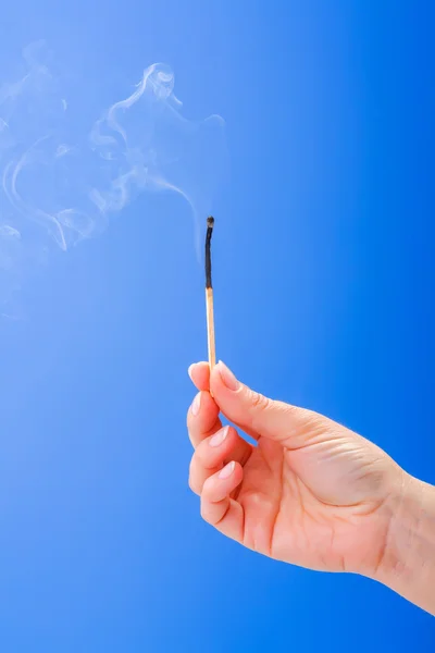 Hand innehav brända rykande matchstick — Stockfoto