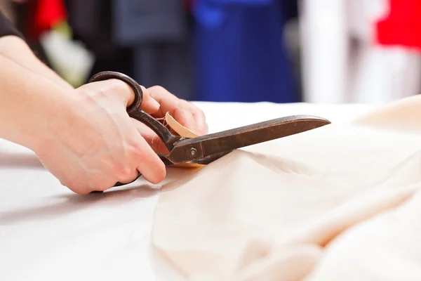 Cutting fabric with big old steel scissors — Stock Photo, Image