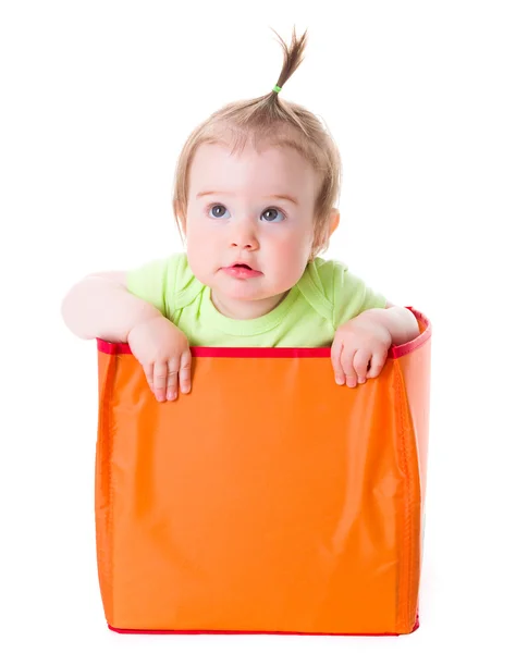 Pretty baby girl sitting in box and looking up — Stockfoto