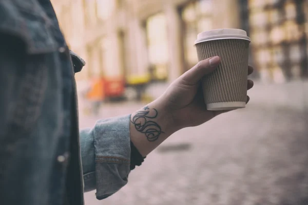Мужская рука с чашкой кофе на улице — стоковое фото