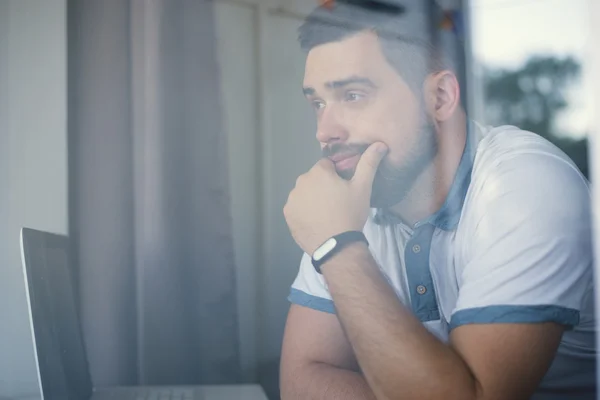 man with fitness tracker in the office through glass window